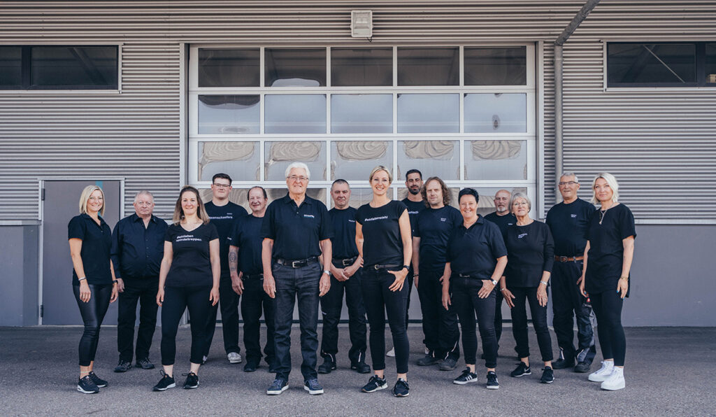 Das ganze Schaefers GmbH Gitterroste und Spindeltreppen Team vor der eigenen Lagerhalle, Gruppenbild.